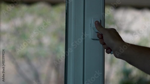 Man opens a white plastic window at home