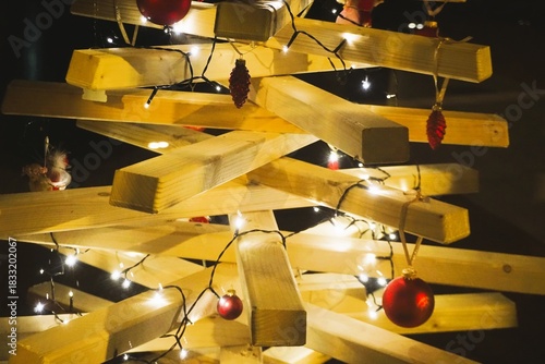 Weihnachtsbaum aus Holz mit Lichterkette in der Nacht im Winter