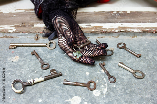 An old key with a bow, a hand in gloves, many antique keys