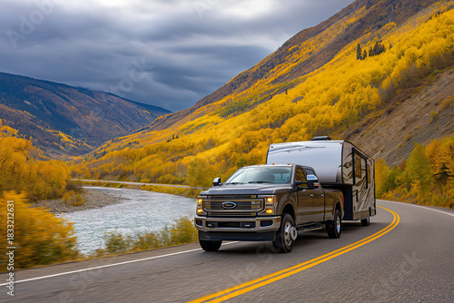 Wallpaper Mural Heavy-Duty Pickup Truck Towing a Fifth Wheel RV Through a Scenic Mountain Valley with Golden Autumn Foliage Torontodigital.ca