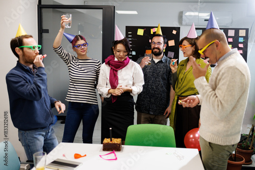 Business team celebrates a successful quarter with a fun party in the office, enjoying drinks and festive decorations during a Friday afternoon gathering