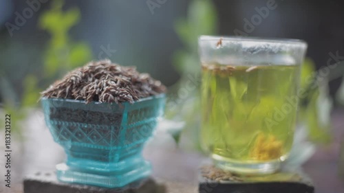 Herbal detoxifying drink i.e. Jeera water with some raw organic cumin in a glass bowl.