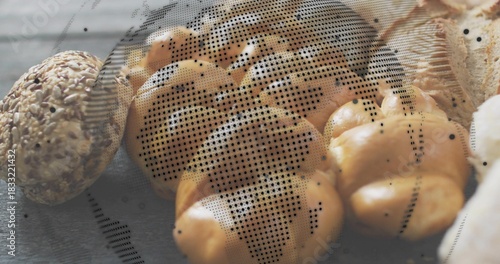 Displaying braided golden-brown loaf gleaming on wooden table, with seeded roll and halftone dots
