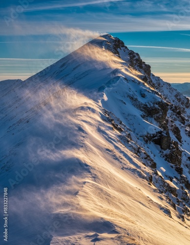Majestic Snow-Capped Mountain Peak with High Winds and Sunlight