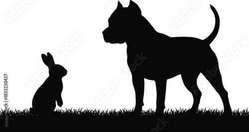Silhouette of a domestic rabbit and a large pit bull-type dog standing face-to-face in grass, representing themes of contrast, companionship, and size difference