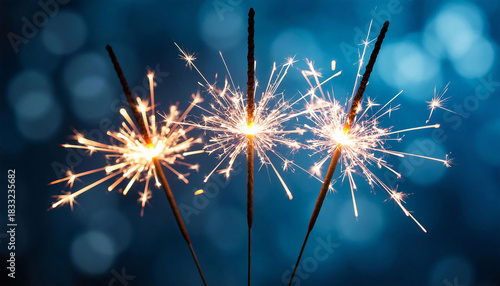 Christmas and New Year party sparklers on blue bokeh background