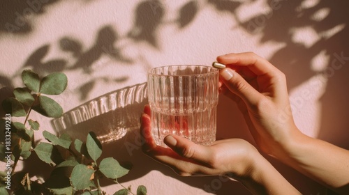 Hand with glass and plant shadow