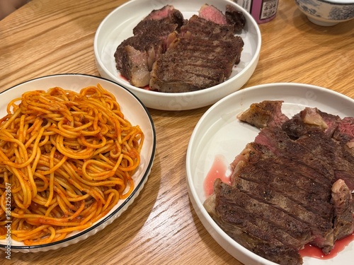 Homemade Steak and Spaghetti Dinner on Wooden Table