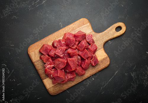 Diced cut raw beef cubes wooden cutting board red meat cooking protein top view