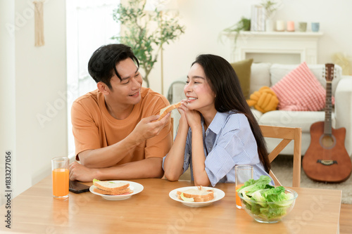 Couple Enjoying Breakfast With Fresh Juice and Sandwiches in a Bright Kitchen Setting