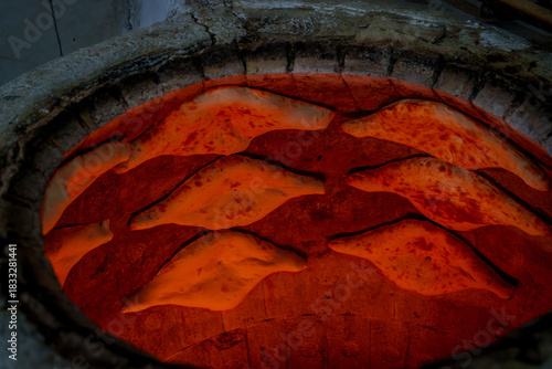 Quadro su tela Traditional Georgian bread baking inside hot tone clay oven