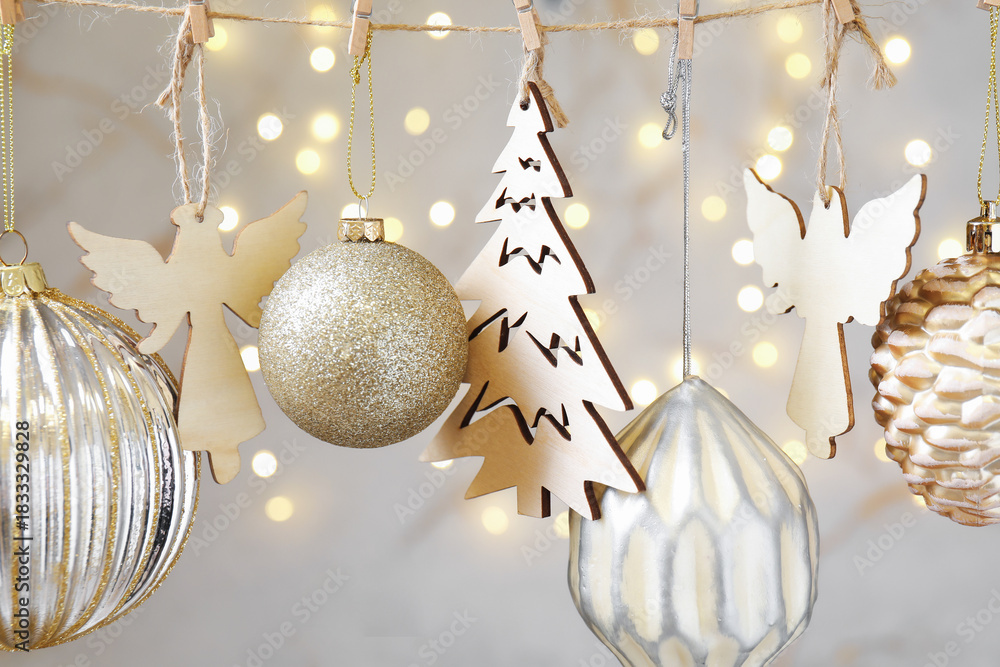 Fototapeta premium Beautiful Christmas decor hanging on string against blurred lights, closeup