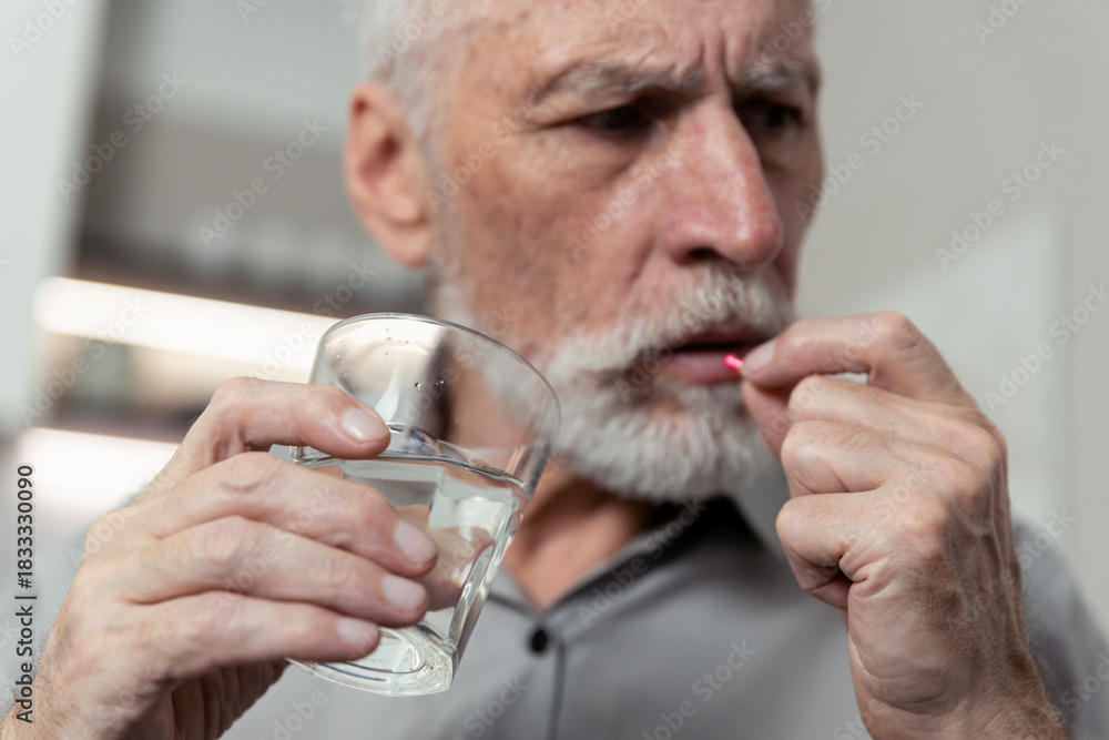 Φωτογραφία Senior man takes medication for mental health care at home