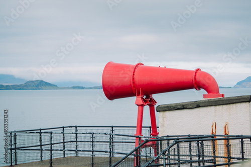 фотографія A striking detailed photograph of the iconic, bright red foghorn located at the base of the Ardnamurchan Lighthouse in the Scottish Highlands