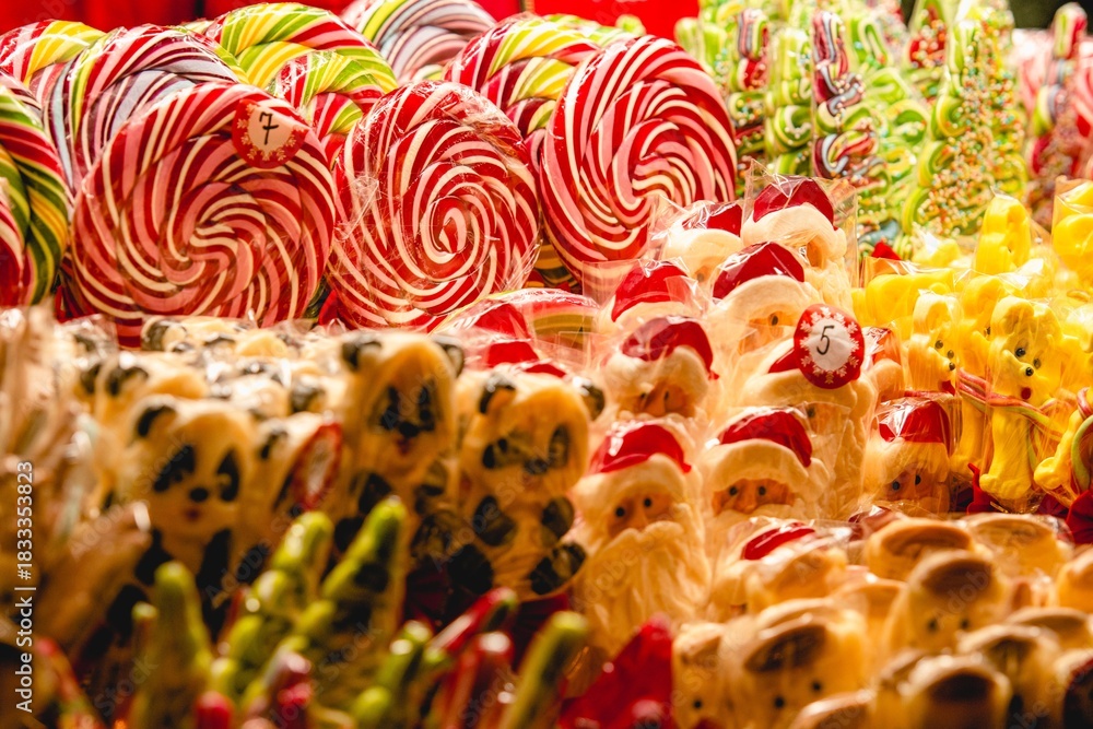 Fototapeta premium Stall or stand with traditional colorful and festive candies and lollipops at the Christmas Market