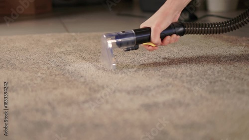 Maintenance technician performs thorough carpet extraction, Professional technician utilizes portable tool to deeply clean and rejuvenate stained commercial carpets