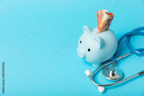 Medical costs, financial concept, health insurance. Stethoscope over dollar bills. Money and piggy bank. Medical care. Health care financial checkup or saving for medical insurance costs concept.