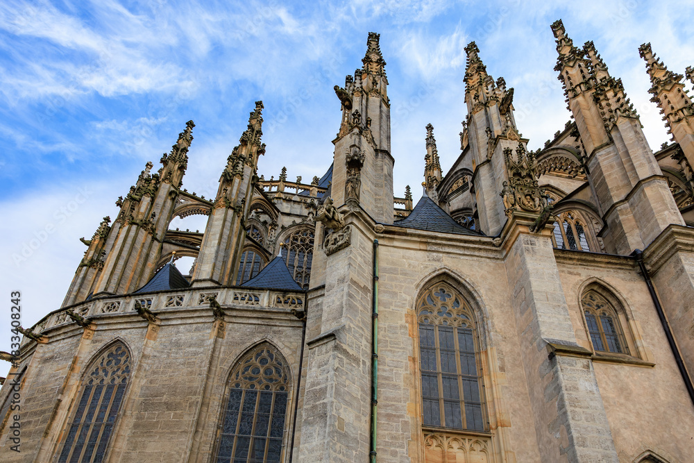 Fototapeta premium Gothic architecture of st. barbara s church facade with dramatic spires under blue sky