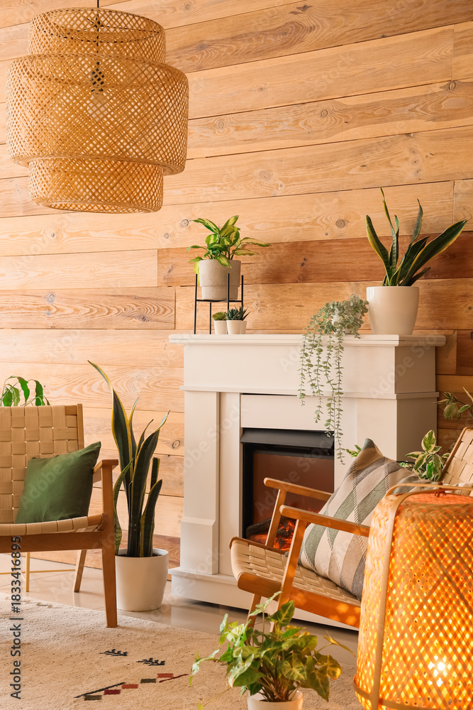 Fototapeta premium Stylish fireplace and armchairs near wooden wall