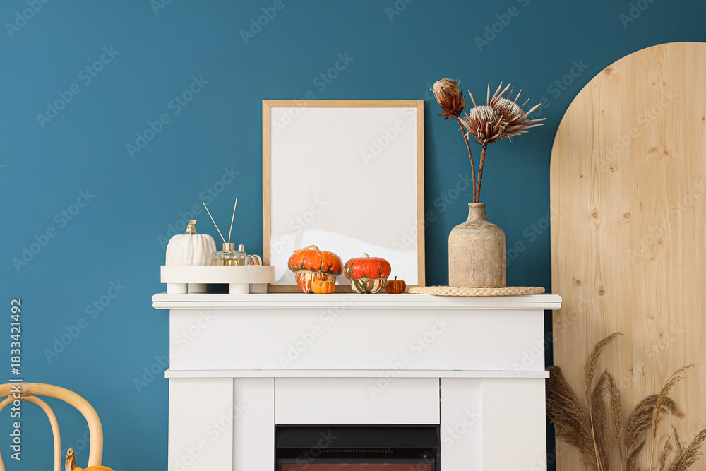 Fototapeta premium White fireplace, vase of flowers and picture in autumn living room, closeup