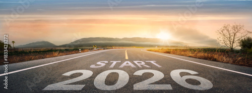 Start 2026 written on highway road in the middle of empty asphalt road of asphalt road at sunset.