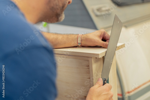 A young craftsman restores a caravan in a hangar.