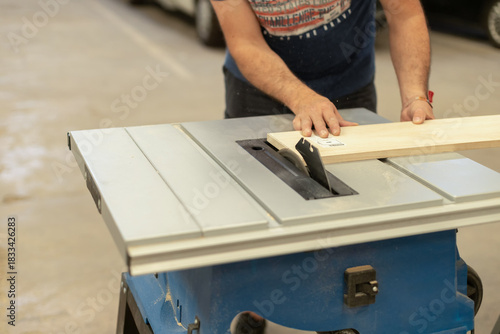 A young craftsman restores a caravan in a hangar.