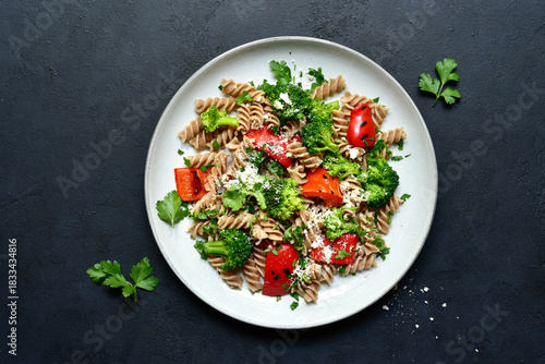 Whole grain pasta fusilli with grilled vegetable and parmesan cheese. Top view with copy space.