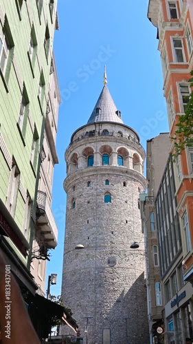 Istanbul, Türkiye, August 1, 2025. One of the city's iconic views: the Galata Tower. Hands can be seen taking photos with cell phones. Vertical format.