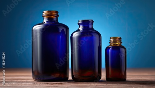 Three dark amber bottles sit on wooden surface