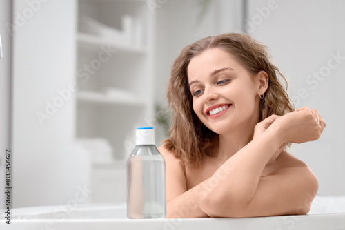 Young woman with bottle of ...