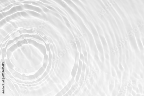 White water with ripples on the surface. Defocus blurred transparent white colored clear calm water surface texture with splashes and bubbles. Water waves with shining pattern texture background.