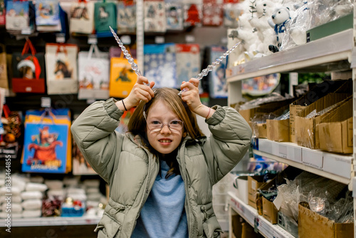 A girl in a store among Christmas decorations. Preparing for the New Year and Christmas. Buying decorations and gifts.