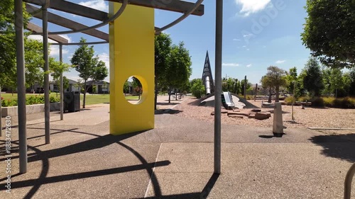 A suburban playground in Tarneit, Melbourne Australia, featuring contemporary play structures, shaded seating areas. Concept of family recreation, urban park design, community outdoor amenities