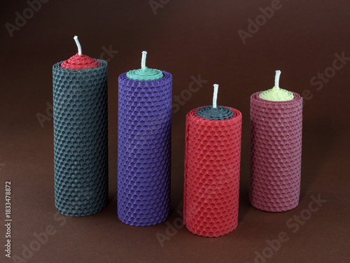 Colorful Hand-Rolled Beeswax Candles Made from Natural Honeycomb Wax on Brown Background – Eco-Friendly. Handmade Beeswax Pillar Candles Set