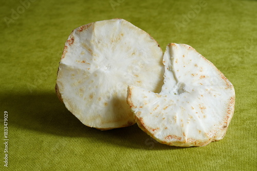 Closeup of pulp of half of celeriac root and a slice