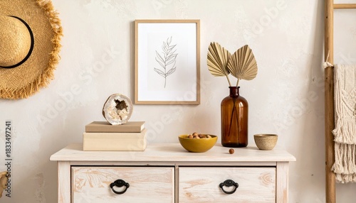 Stylish boho interior of living room with brown mock up poster frame, elegant accessories, flowers in vase, wooden shelf and hanging rattan hut. Minimalistic concept of home decor. Template