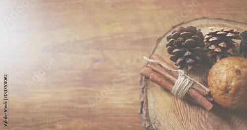 Fototapeta samoprzylepna Showing rustic cluster on wood slab at table, with pinecones, tied cinnamon sticks, copy space