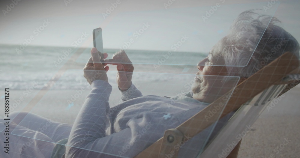 Obraz premium Reclining senior woman using smartphone on deckchair at shore in gray top, blue-overlay, copy space