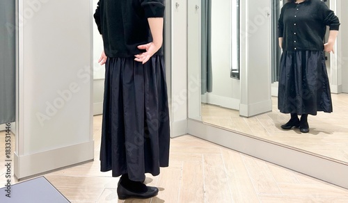 Bild auf Leinwand 若い女性は試着室で試着している