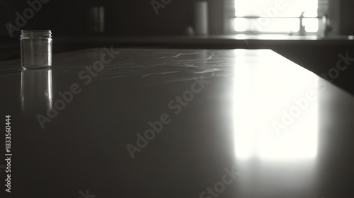 countertop. A clean and reflective black kitchen countertop, presenting a minimalist and abstract domestic scene. lifestyle magazines.