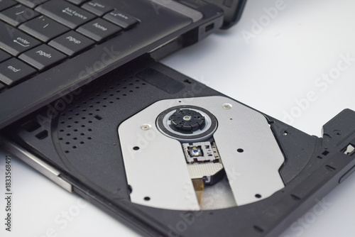 Close-up of laptop CD/DVD optical drive on white background, detailed electronic component for technology, repair, or data storage concept in minimal studio lighting
