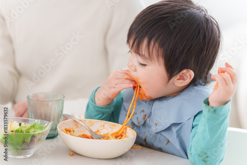 食べ物を手づかみ食べをする子供