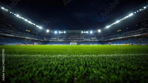 A vibrant soccer stadium at night, illuminated by powerful spotlights, showcasing a lush green playing field.