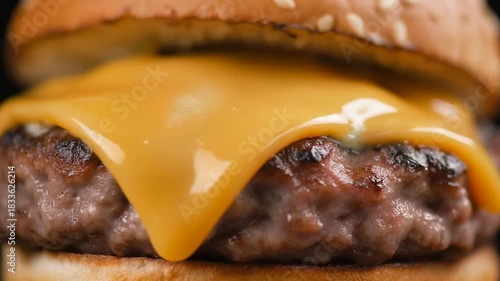 Close-up of a cheeseburger with melted cheese on a beef patty.