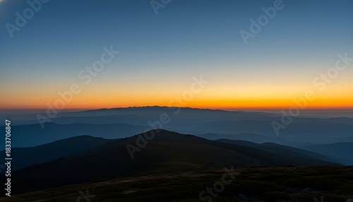 Wallpaper Mural A serene mountain landscape at dawn or dusk, with layers of peaks silhouetted against a vibrant gradient sky. Torontodigital.ca