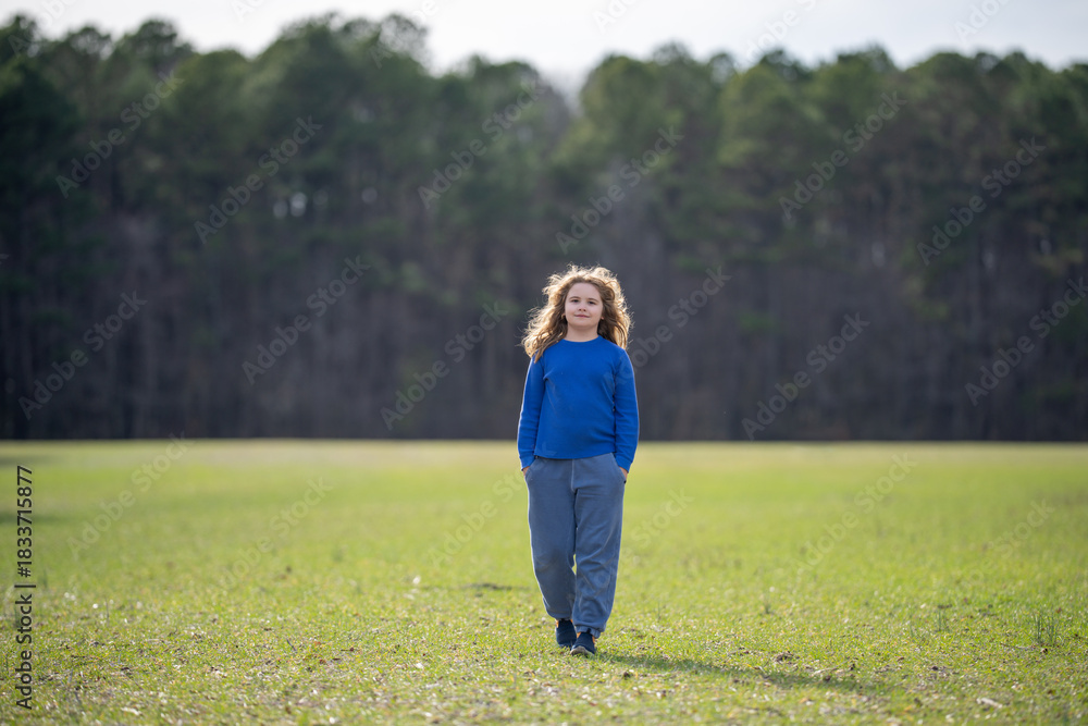 Obraz premium Carefree child in a meadow. Child imagining. Outdoor portrait of a dreamer kid. Freedom and innocence in childhood. Cute child outdoor portrait. Dreamy kids face. Carefree childhood. Dreamy child.