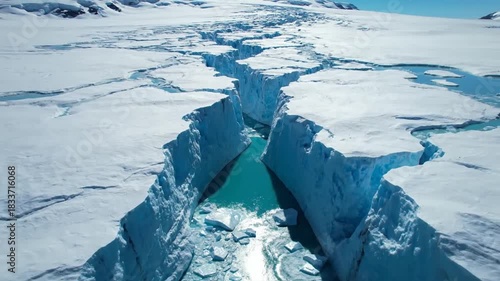 Aerial view of a glacial crevasse with turquoise water and snow covered terrain natural environment