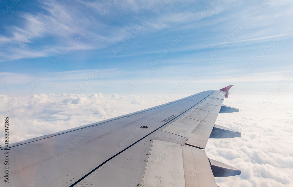 Obraz premium View from the airplane window at a beautiful cloudy sky and the airplane wing
