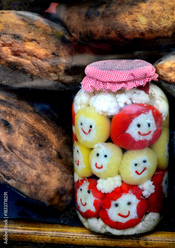 Jar of funny assorted pickles on a background of homemade bread